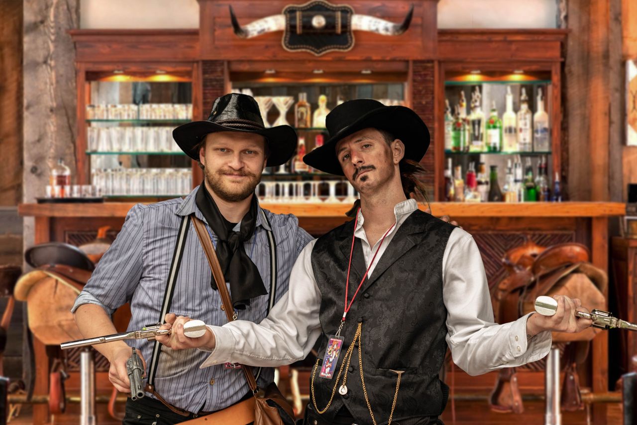 Mastering the First Impression: Your intriguing post title goes here Two men in cosplay cowboy attire with guns in a Western-themed bar setting.